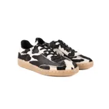 Championes de diseño artesanal con exterior de pelo natural con estampado de manchas tipo vaca en blanco y negro. Presenta cordones negros, interior forrado y suela de goma color caramelo.