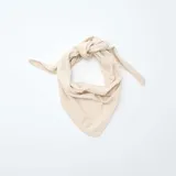 Bufanda triangular de tejido suave y ligero en color beige, con diseño anudable.