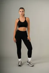 Conjunto deportivo gris compuesto por un top con tirantes finos y calzas de cintura alta.