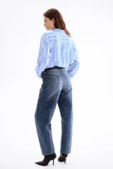 Camisa oversize confeccionada en mezcla de lino y viscosa, con diseño a rayas verticales en tonos celeste y blanco. Cuenta con cuello clásico, cierre frontal de botones, hombros caídos y mangas largas con puños abotonados.