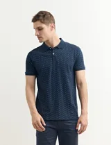 Remera polo azul marino con estampado de pequeños puntos blancos, cuello clásico con tres botones y mangas cortas.