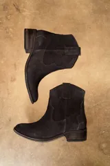 Bota corta estilo texano confeccionada en cuero vacuno, con taco cuadrado de madera y costuras decorativas en el lateral.