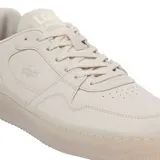Championes Lacoste modelo L001 Set, de diseño urbano y minimalista en color beige. Presentan una silueta clásica con capellada de cuero texturizado, el icónico logo del cocodrilo grabado en el lateral y una suela de goma translúcida que aporta un toque moderno.
