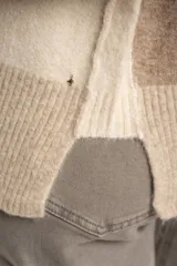Sweater de punto con diseño color block en tonos beige y arena, de cuello redondo, manga larga raglán y puños y ruedo acanalados.