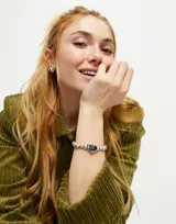 Pulsera elástica de bolas bañadas en plata con un cristal facetado grisáceo.