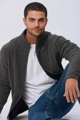 Campera gris de polar texturado liviano, con cuello alto, cierre frontal y bolsillos laterales con cierre.