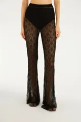 Pantalón acampanado de encaje negro con diseño transparente y tiro alto.