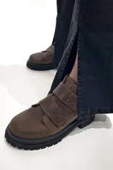 Botas marrones de cuero con suela track negra y ajuste con dos tiras de velcro.