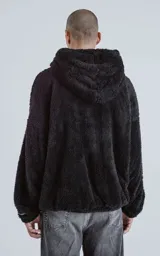 Hoodie oversize tipo anorak confeccionado en piel sintética de corderito, color negro. Presenta cierre central parcial, capucha ajustable con cordones y bolsillo canguro frontal.