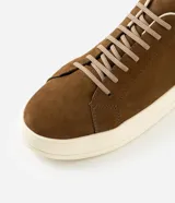 Championes de cuero nobuk en color marrón, con cordones elásticos y suela alta de goma en tono marfil.