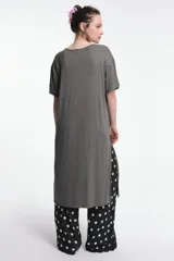 Vestido midi color beige, de corte oversized, con cuello redondo, manga corta y tajos laterales. Presenta un parche decorativo en la manga.