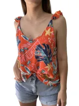 Musculosa estampada color naranja con hojas y flores en tonos azules, amarillos y celestes. Tiene breteles anchos con volados.