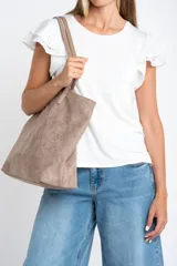 Remera negra de viscosa y elastano, con escote redondo y mangas cortas con volado de tela perforada (broderie).