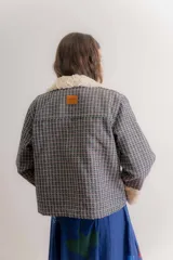 Chaqueta de jacquard con diseño a cuadros, cuello y puños de piel sintética, cierre frontal y bolsillos laterales.