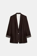 Blazer de lino color verde militar, con cuello solapa, hombreras y manga larga con puño revuelto con detalle a rayas. Cuenta con cierre frontal de un botón y bolsillos delanteros con solapa.
