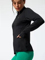 Campera deportiva de manga larga color negro con medio cierre frontal y cuello alto, confeccionada en tejido suave con spandex.