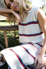 Vestido midi tejido en hilo de algodón, sin mangas y con escote redondo. Presenta un diseño de rayas horizontales en tonos beige, azul y rojo.