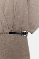 Vestido midi de escote en pico cruzado y manga corta. Presenta detalle de frunces en la cintura y un cinturón integrado con hebilla metálica a contraste.