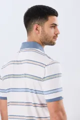 Remera polo de manga corta con diseño a rayas horizontales en tonos azules, celestes, verdes y beiges sobre base azul marino. Presenta cuello camisero con cierre frontal de botones y un pequeño logo bordado en el pecho.