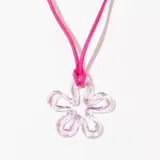 Collar con dije de flor transparente con efecto iridiscente y cordón fucsia.
