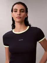 Remera Calvin Klein de corte baby fit y manga corta, confeccionada en tejido acanalado negro. Presenta cuello redondo y puños con ribetes en contraste blanco y amarillo fluo, y el logo de la marca bordado en el pecho.