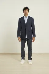 Saco azul de lino con dos botones, solapa de muesca, dos bolsillos delanteros con solapa y un bolsillo en el pecho.