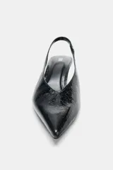 Zapato destalonado con tacón fino, acabado en punta y textura con efecto relieve. Cuenta con tira trasera elástica para mayor ajuste.