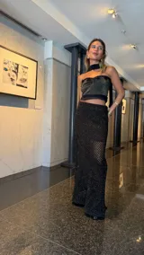 Falda larga negra de tejido red calada con lurex dorado, pretina elástica y tajos laterales. Incluye forro en la zona del caderín.