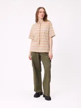 Remera de corte holgado con diseño de rayas horizontales en tonos beige, rosa y verde oliva. Presenta cuello redondo, mangas cortas y un bolsillo frontal pequeño con el logo de la marca.