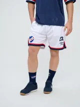 Short de fútbol Umbro del Club Nacional de Football, modelo oficial para hombre. Diseño en color blanco con tejido de malla transpirable, detalles en azul y rojo en el borde inferior, escudo del club en una pierna y el número 22 con el logo de Umbro en la otra.