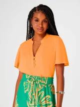 Blusa color naranja con escote en V y botones frontales. Manga corta.