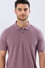 Remera polo de piqué de algodón color azul, de manga corta, con cuello camisero, cierre frontal de dos botones y pequeño logo bordado en el pecho.