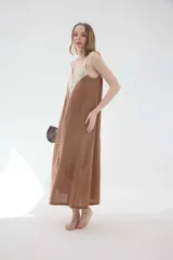 Vestido midi lencero marrón de lino, con escote en V pronunciado con aplique de encaje en contraste, breteles regulables y botonadura frontal decorativa.