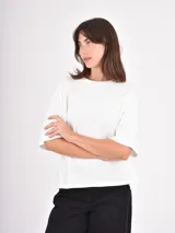 Remera de algodón color negro, con cuello redondo, corte holgado y mangas cortas con dobladillo ancho.