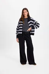 Pantalón de jean negro de corte recto y pierna ancha, con cintura elástica ajustable mediante cordón. Presenta costuras en contraste color cobre.