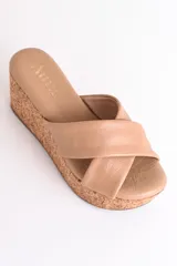 Sandalia color beige con plataforma de corcho y tiras cruzadas de cuero.