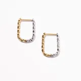 Aros rectangulares de acero enchapado, mitad dorados y mitad plateados, con textura facetada.