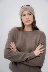 Vincha de lana color beige, tejida a mano, con diseño trenzado en el frente.