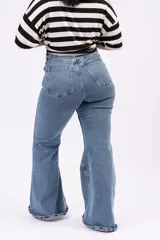 Pantalón jean estilo oxford de tiro alto, color azul intermedio, con calce ajustado en cadera y muslos, y bota ancha acampanada.