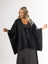 Ruana color beige de tejido liviano con destellos de mini lentejuelas.