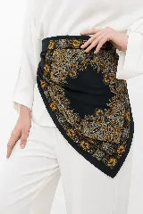 Pañuelo cuadrado de tela suave con estampado estilo paisley en tonos negro, ocre y gris.