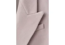 Abrigo largo de paño color gris, de corte recto y diseño cruzado con doble botonadura oscura. Cuenta con solapas amplias, hombreras marcadas, bolsillos con solapa en los laterales y abertura en la parte trasera.