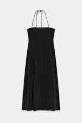 Vestido largo de color negro con cuello halter y escote recto. Presenta un diseño fluido con cierre de cremallera oculta en la espalda y lazada ajustable en el cuello.