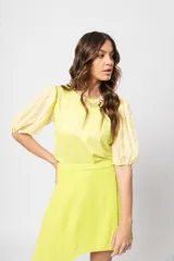 Blusa verde con cuello redondo y mangas cortas abullonadas.