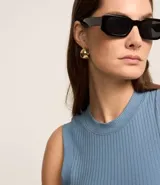 Blusa sin mangas color blanco, confeccionada en tejido de punto acanalado, con cuello redondo.