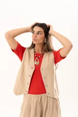 Chaleco de corte sastre en color beige, con escote en V, cierre frontal mediante botones y costuras decorativas en contraste.
