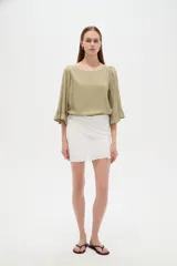 Minifalda blanca de viscosa con diseño cruzado y frunces en la cintura.