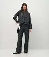 Chaleco de punto gris oscuro con textura jaspeada, diseño sin mangas, corte holgado y cuello alto tipo mock neck.