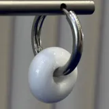 Aros tipo argolla con dije en forma de dona de vidrio color blanco. Base de plata 925.