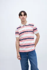 Chomba teñida en prenda con estampado a rayas, confeccionada en algodón lavado. Presenta media cartera de botones y bordado en el pecho.